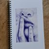 carnet à spirales illustré par un dessin au stylo bic d'une bouche boudeuse