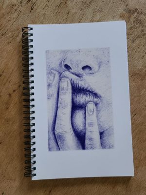 carnet à spirales illustré par un dessin au stylo bic d'une bouche boudeuse